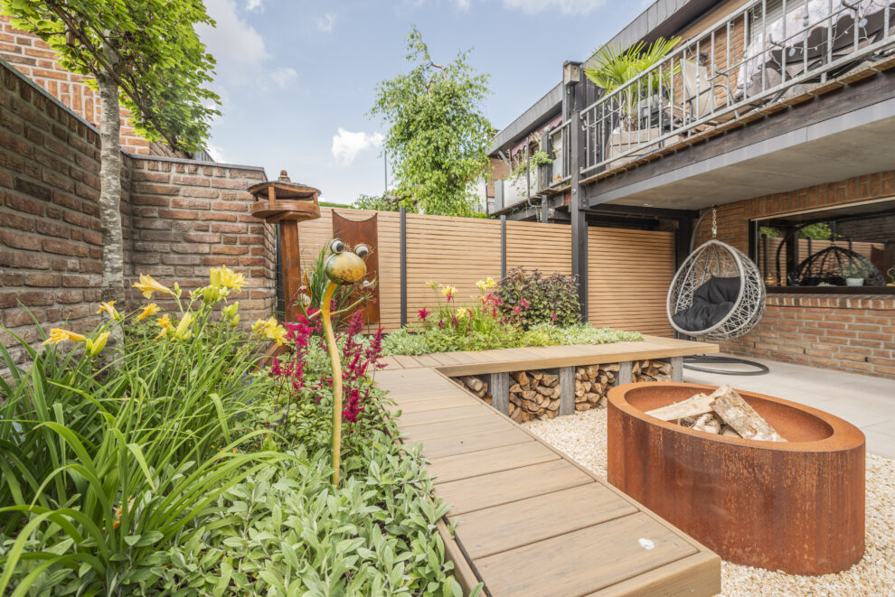 Terrassengestaltung mit Feuerschale in einem Garten mit farbenfroher Bepflanzung.