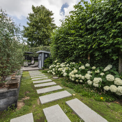 Gartenweg mit Trittplatten und Blick auf den modernen Sitzbereich.